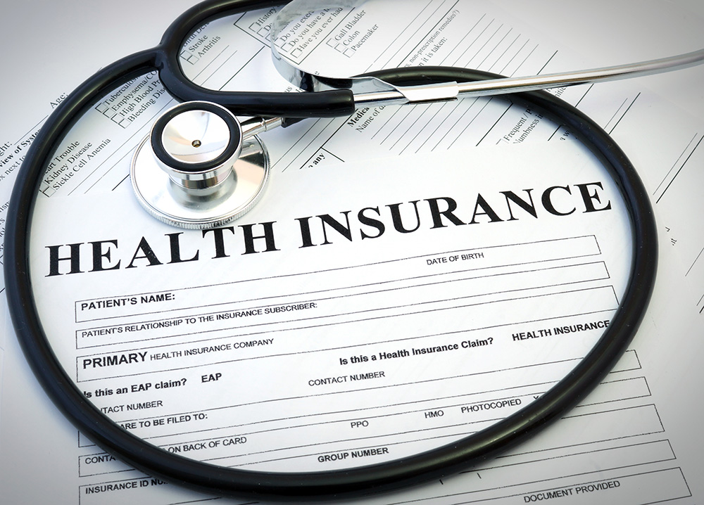 A stethoscope is placed on top of health insurance forms. The forms include headings such as "Health Insurance" and sections for patient information. The image symbolizes healthcare, insurance coverage, and membership in a trusted medical support network.